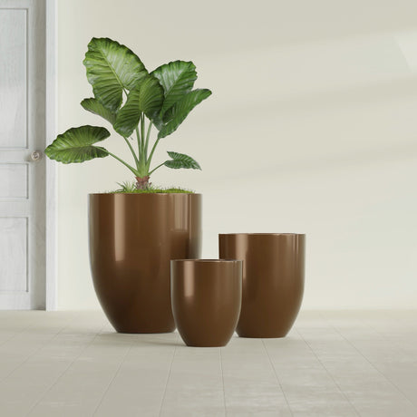 Valencia Tapered Round fiberglass planter in Metallic Bronze, size range, in a sunlit interior