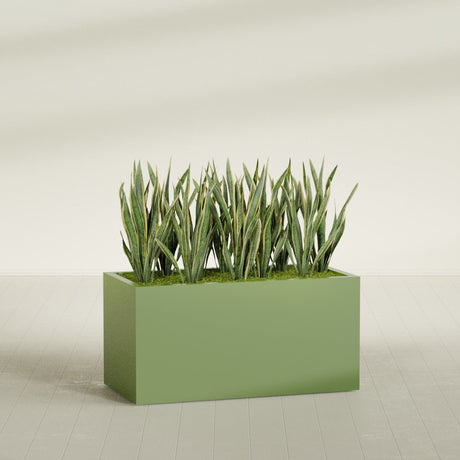 Granada fiberglass planter in Satin Green, shown planted, in a sunlit interior