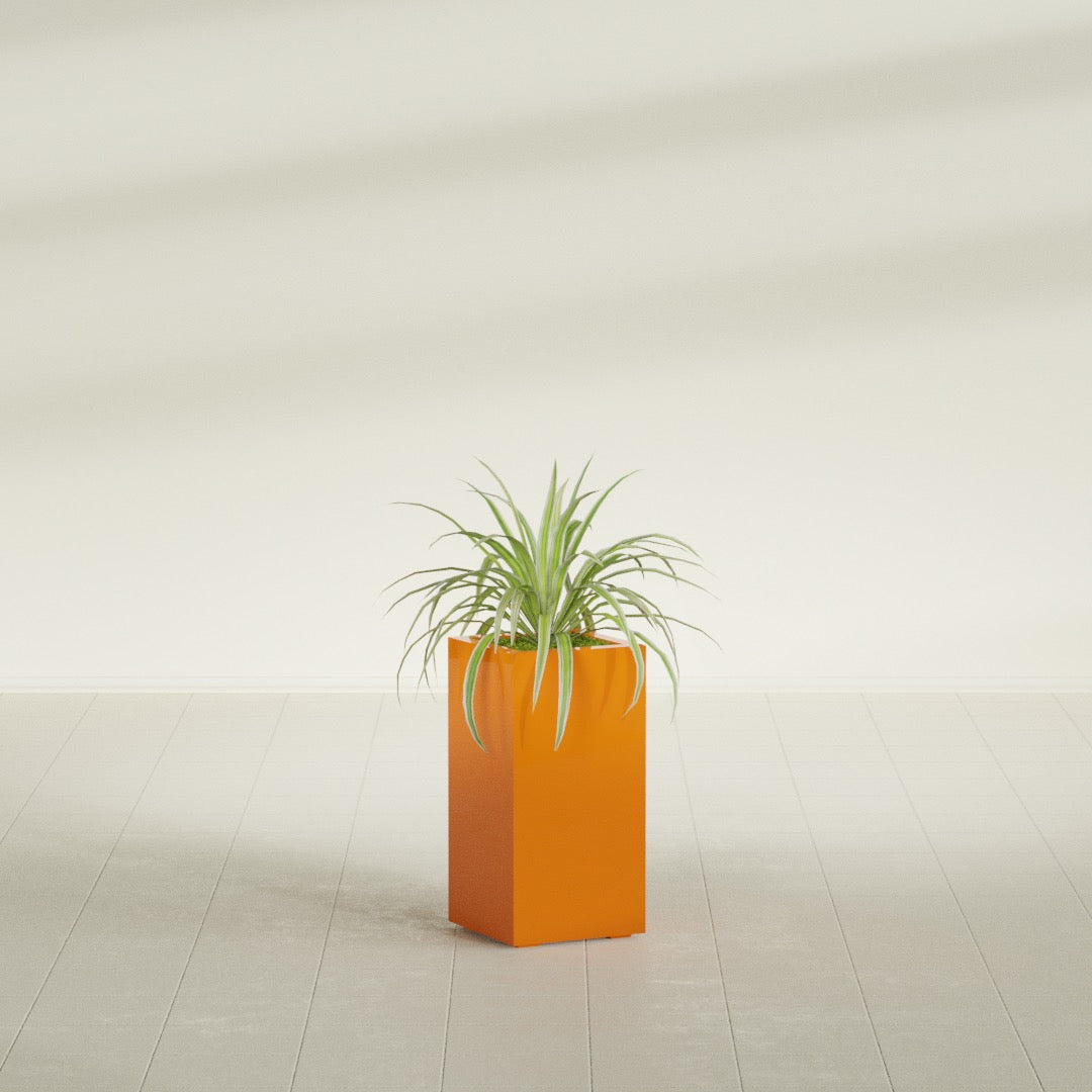 Hollywood Corner fiberglass planter in Gloss Tangerine, shown planted, in a sunlit interior