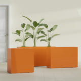 Milano Narrow Rectangular fiberglass planter in Gloss Tangerine, shown planted, in a sunlit interior