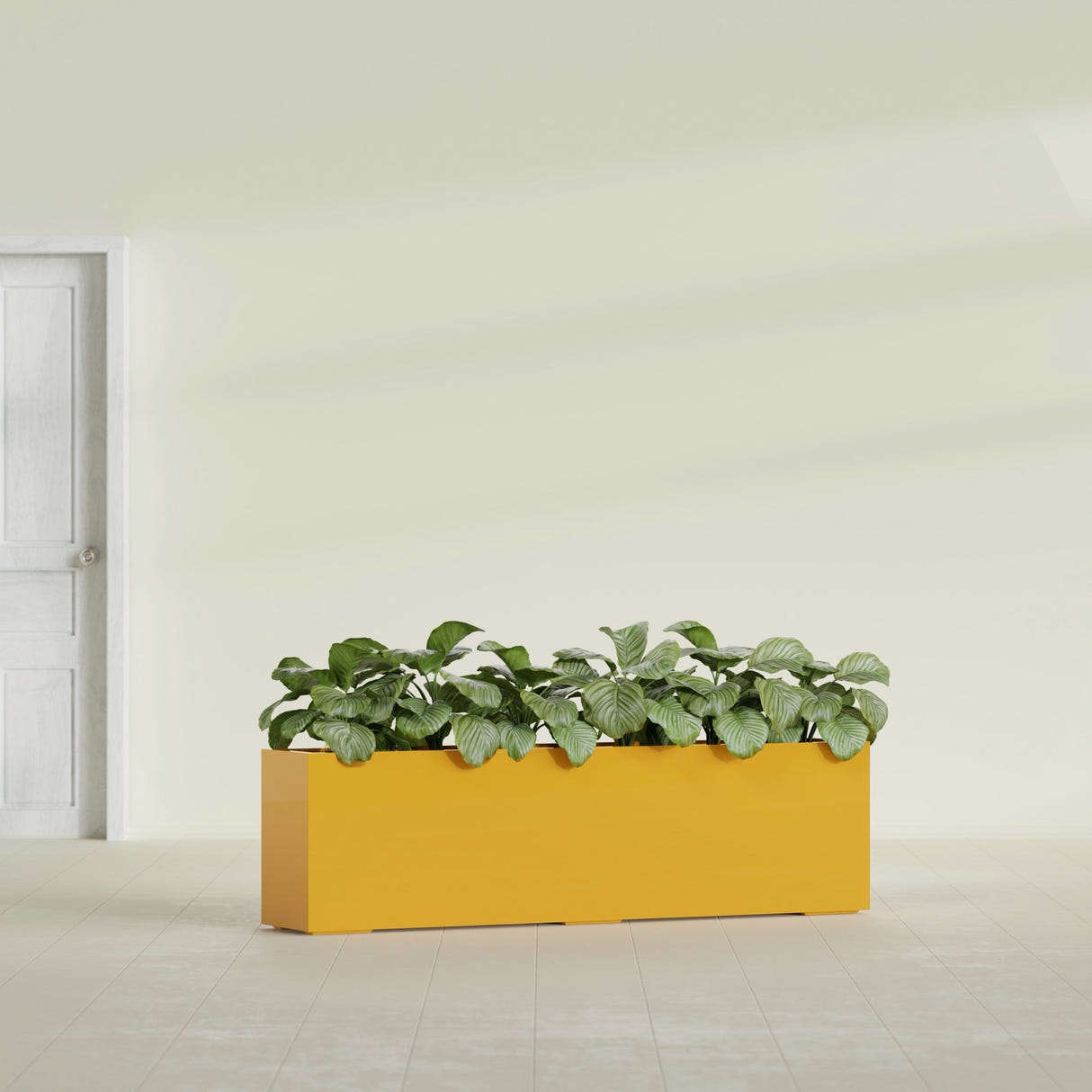 Hudson Extra Long fiberglass planter in Gloss Saffron, shown planted, in a sunlit interior