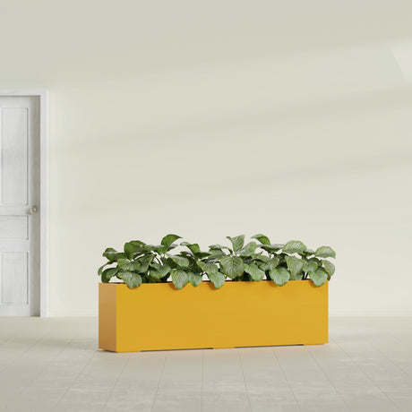 Hudson Extra Long fiberglass planter in Gloss Saffron, shown planted, in a sunlit interior