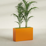 Potsdam Corner fiberglass planter in Gloss Tangerine, shown planted, in a sunlit interior