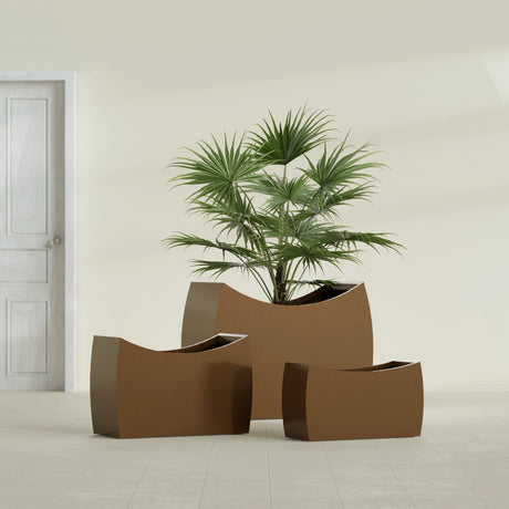 Seoul Curved fiberglass planter in Metallic Bronze, size range, in a sunlit interior