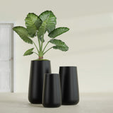Saigon Tapered Round fiberglass planter in Matte Black, size range, in a sunlit interior