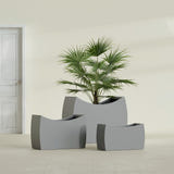 Seoul Curved fiberglass planter in Matte Gunmetal, size range, in a sunlit interior