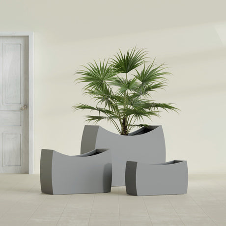 Seoul Curved fiberglass planter in Matte Gunmetal, size range, in a sunlit interior