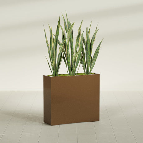 Delray Corner fiberglass planter in Metallic Bronze, shown planted, in a sunlit interior