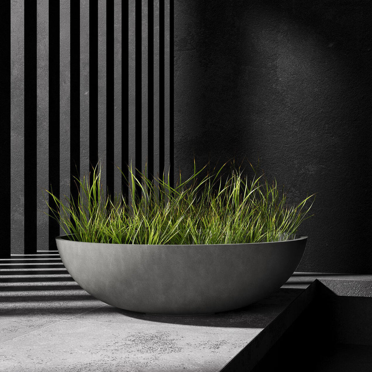 Cavo low bowl Cosapots fiberglass planter, shown planted with ornamental grasses against a slatted timber wall.