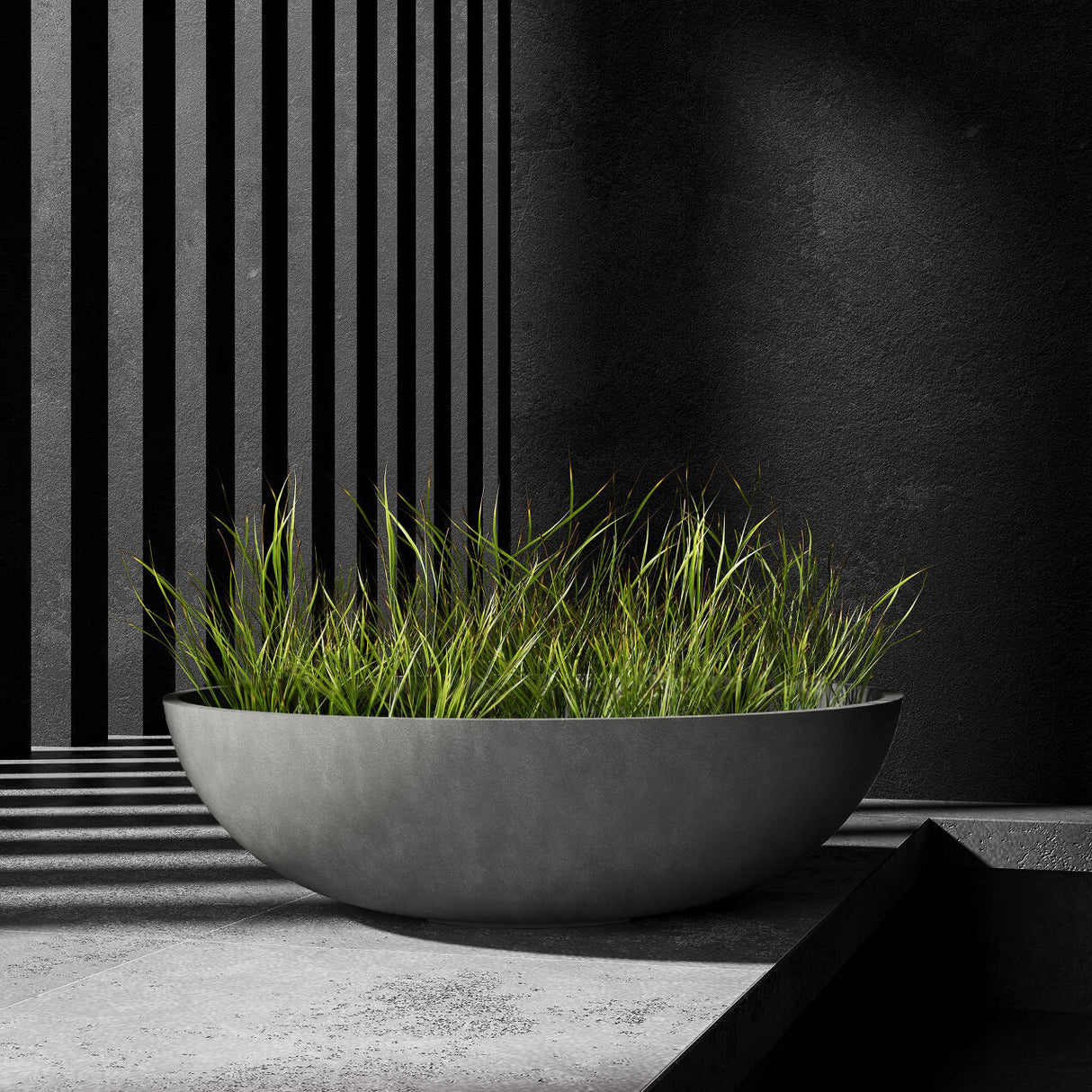 Cavo low bowl Cosapots fiberglass planter, shown planted with ornamental grasses against a slatted timber wall.