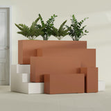 Hollywood Narrow Rectangular fiberglass planter in Matte Terra Cotta, size range, in a sunlit interior