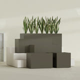 Granada fiberglass planter in Matte Bronze, size range, in a sunlit interior