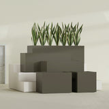 Granada fiberglass planter in Matte Bronze, size range, in a sunlit interior