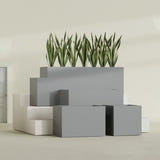Granada fiberglass planter in Matte Gunmetal, size range, in a sunlit interior