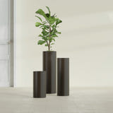 Corry Cylinder fiberglass planter in Matte Dark Brown, size range, in a sunlit interior