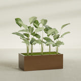 Torino Wide Rectangular fiberglass planter in Metallic Bronze, shown planted, in a sunlit interior
