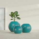 Globe fiberglass planter in Satin Seafoam Green, size range, in a sunlit interior