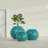 Globe fiberglass planter in Satin Seafoam Green, size range, in a sunlit interior