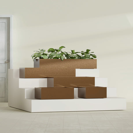 Antwerp Corner fiberglass planter in Metallic Bronze, size range, in a sunlit interior