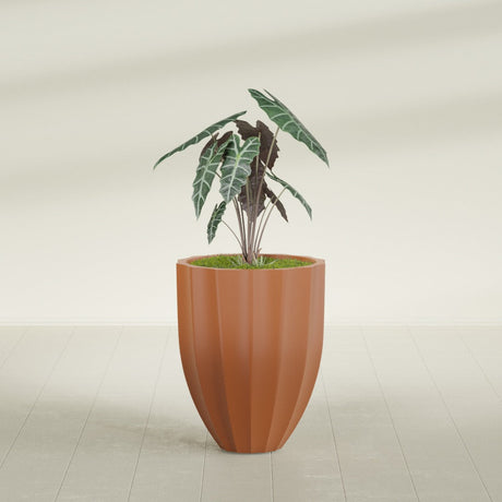 Alicante Fluted fiberglass planter in Matte Terra Cotta, shown planted, in a sunlit interior