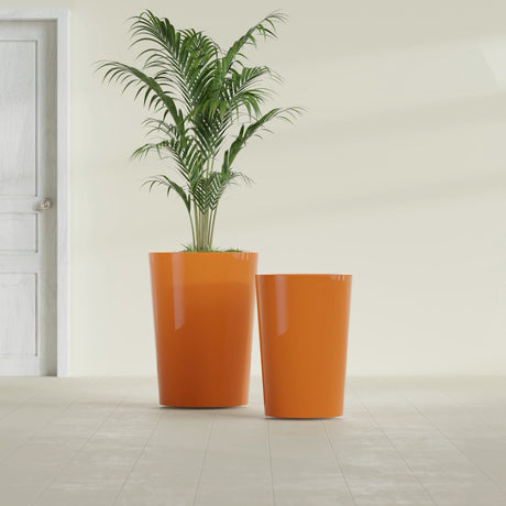 Tegel Round Tapered fiberglass planter in Gloss Tangerine, size range, in a sunlit interior