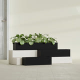 Monaco Rectangle fiberglass planter in Matte Black, shown planted, in a sunlit interior