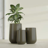 Hayden Urn fiberglass planter in Matte Bronze, size range, in a sunlit interior