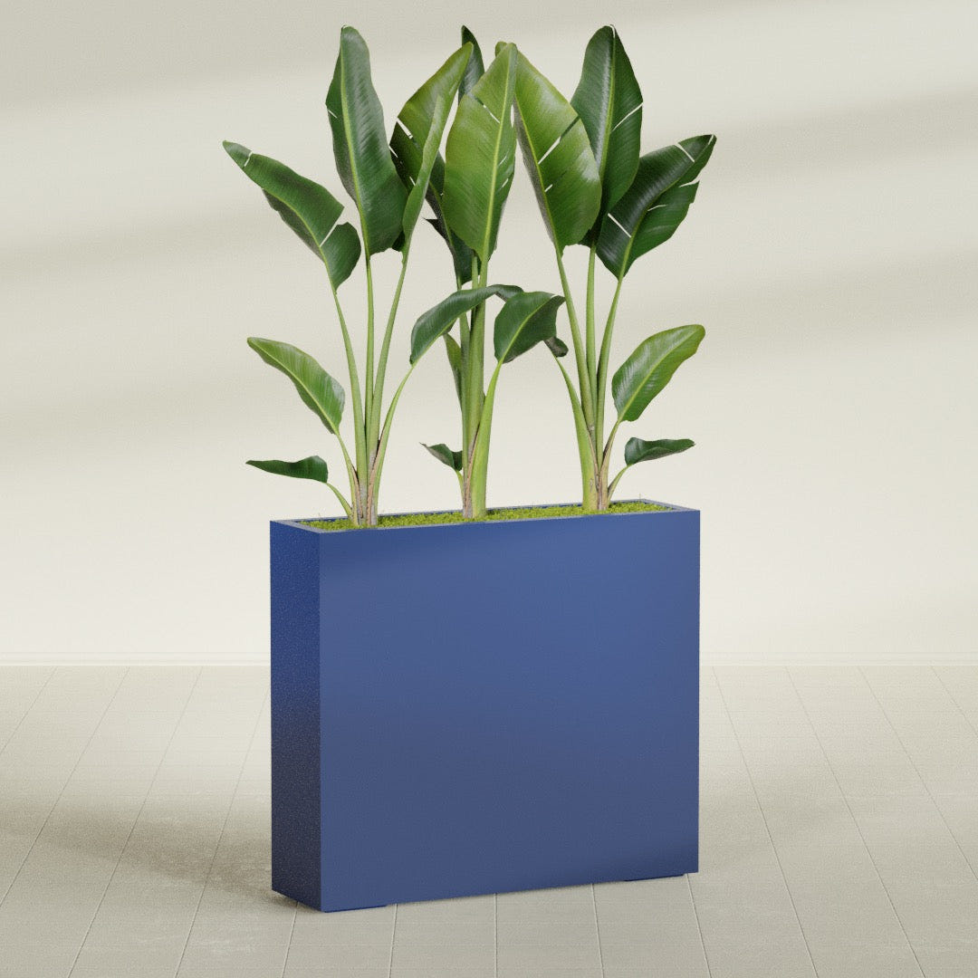 Amesbury Narrow Rectangular fiberglass planter in Matte Cobalt Blue, shown planted, in a sunlit interior