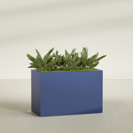 Brisbane Rectangular fiberglass planter in Matte Cobalt Blue, shown planted, in a sunlit interior