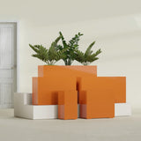 Potsdam Corner fiberglass planter in Gloss Tangerine, size range, in a sunlit interior