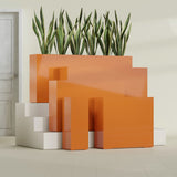Delray Corner fiberglass planter in Gloss Tangerine, size range, in a sunlit interior