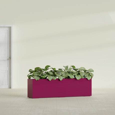 Hudson Extra Long fiberglass planter in Gloss Eggplant, shown planted, in a sunlit interior