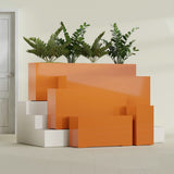 Hollywood Narrow Rectangular fiberglass planter in Gloss Tangerine, size range, in a sunlit interior