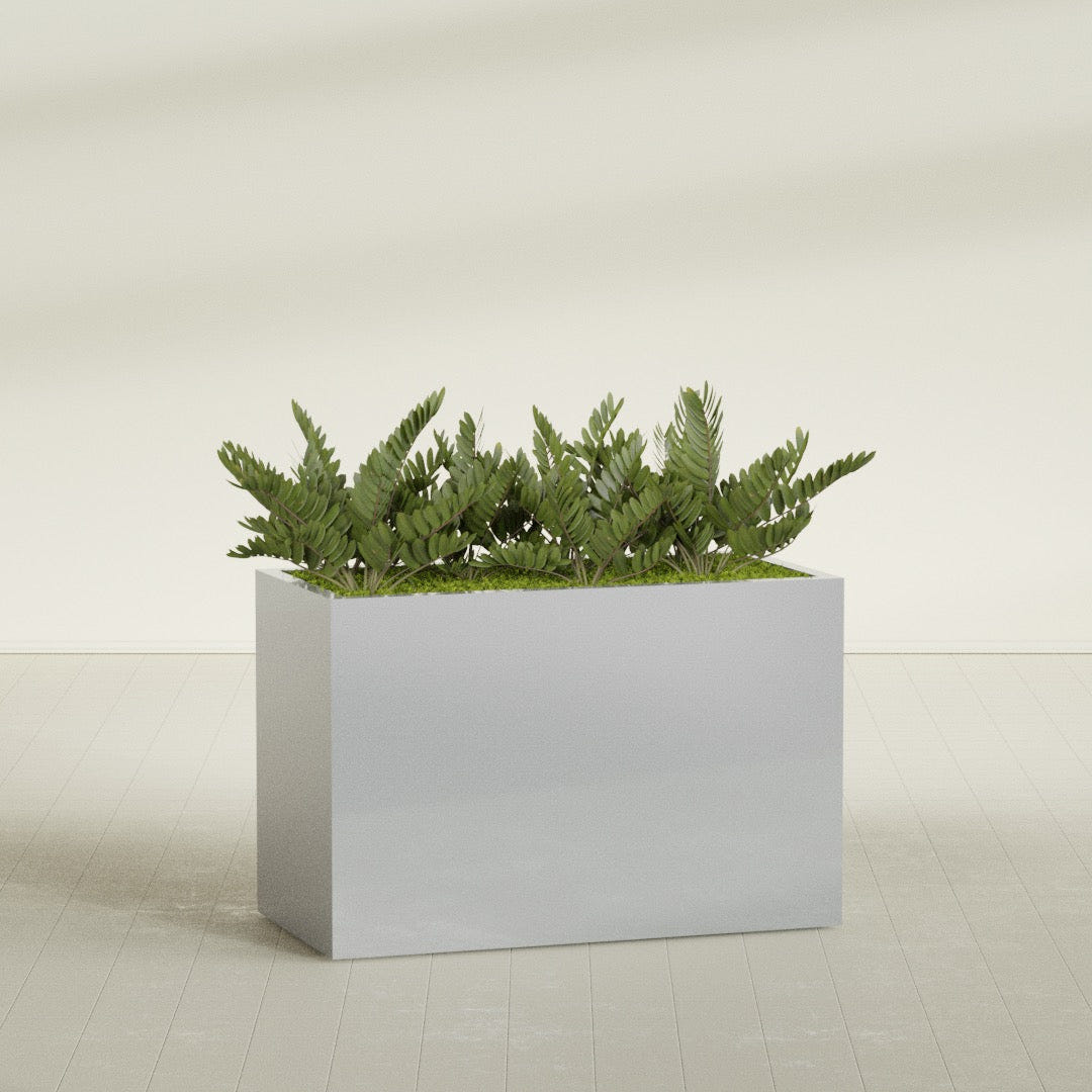 Brisbane Corner fiberglass planter in Metallic Silver, shown planted, in a sunlit interior