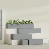 Cuba Low Rectangular fiberglass planter in Matte Gunmetal, size range, in a sunlit interior