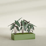 Antwerp Corner fiberglass planter in Satin Green, shown planted, in a sunlit interior