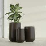 Hayden Urn fiberglass planter in Matte Dark Brown, size range, in a sunlit interior