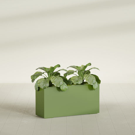 Miami Corner fiberglass planter in Satin Green, shown planted, in a sunlit interior