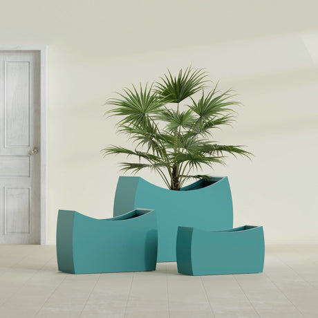 Seoul Curved fiberglass planter in Satin Seafoam Green, size range, in a sunlit interior