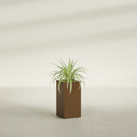 Hollywood Corner fiberglass planter in Metallic Bronze, shown planted, in a sunlit interior
