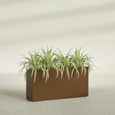Hollywood Narrow fiberglass planter in Metallic Bronze, planted, in a sunlit interior