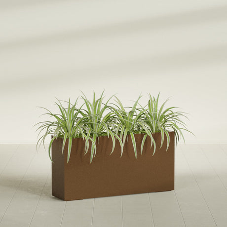Hollywood Narrow fiberglass planter in Metallic Bronze, planted, in a sunlit interior
