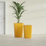 Tegel Round Tapered fiberglass planter in Gloss Saffron, size range, in a sunlit interior