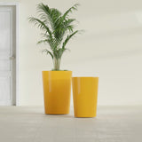 Tegel Round Tapered fiberglass planter in Gloss Saffron, size range, in a sunlit interior