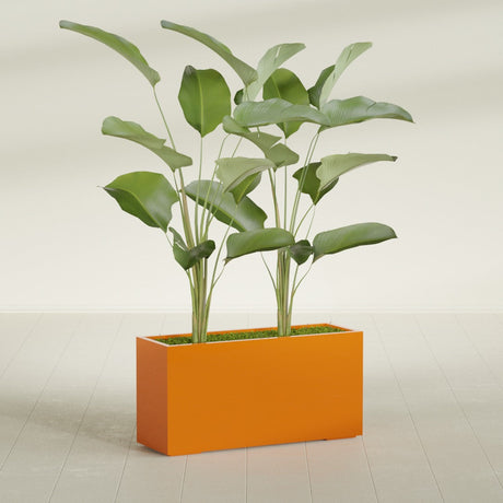 Tolga Corner fiberglass planter in Gloss Tangerine, shown planted, in a sunlit interior
