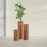 Corry Cylinder fiberglass planter in Matte Terra Cotta, size range, in a sunlit interior