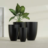 Brannan Tapered Round fiberglass planter in Matte Black, size range, in a sunlit interior