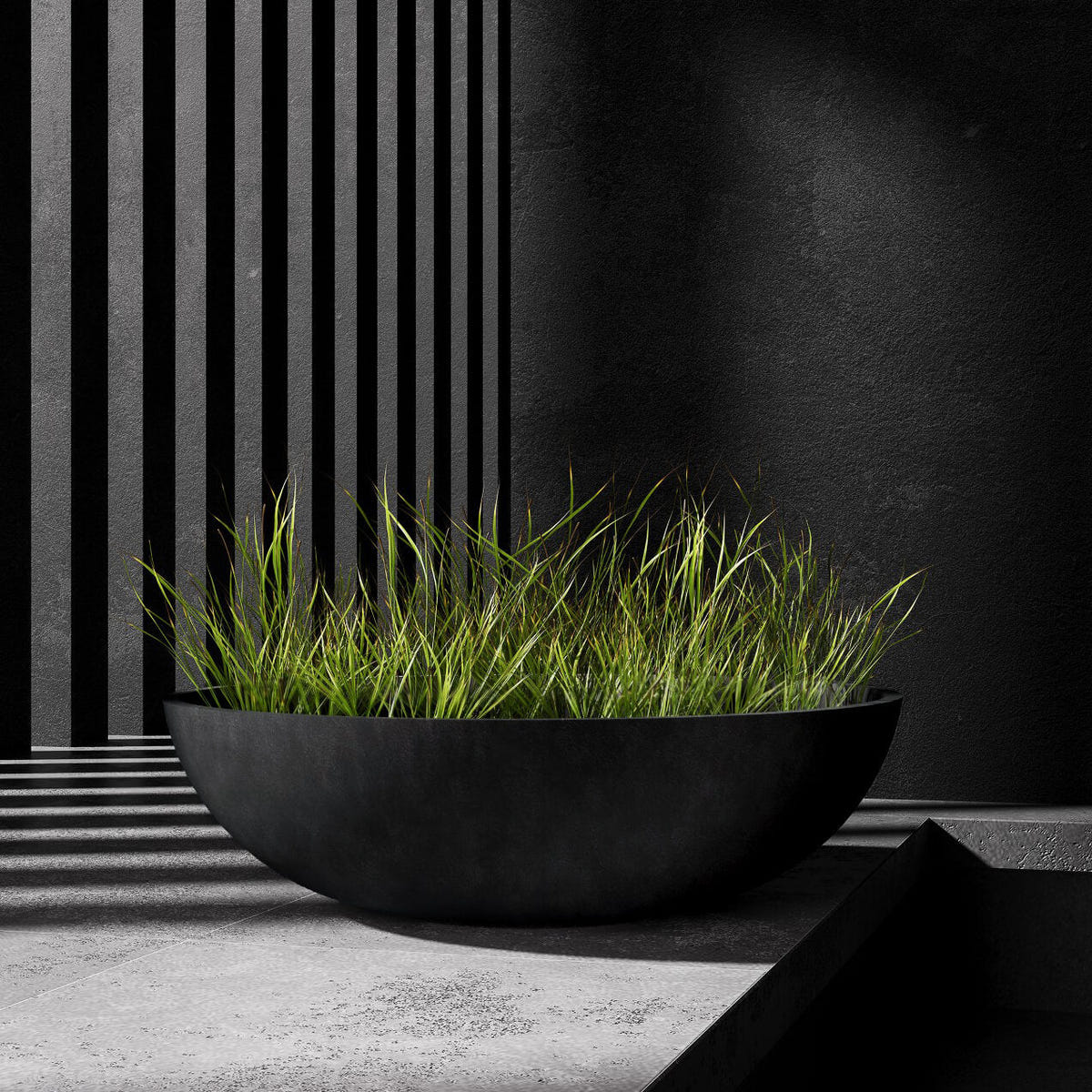 Cavo low bowl Cosapots fiberglass planter, shown planted with ornamental grasses in a styled setting.
