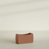 Seoul Curved Planter in Matte Terra Cotta, 32"L × 12"D × 18"H, shown empty