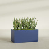 Granada fiberglass planter in Matte Cobalt Blue, shown planted, in a sunlit interior